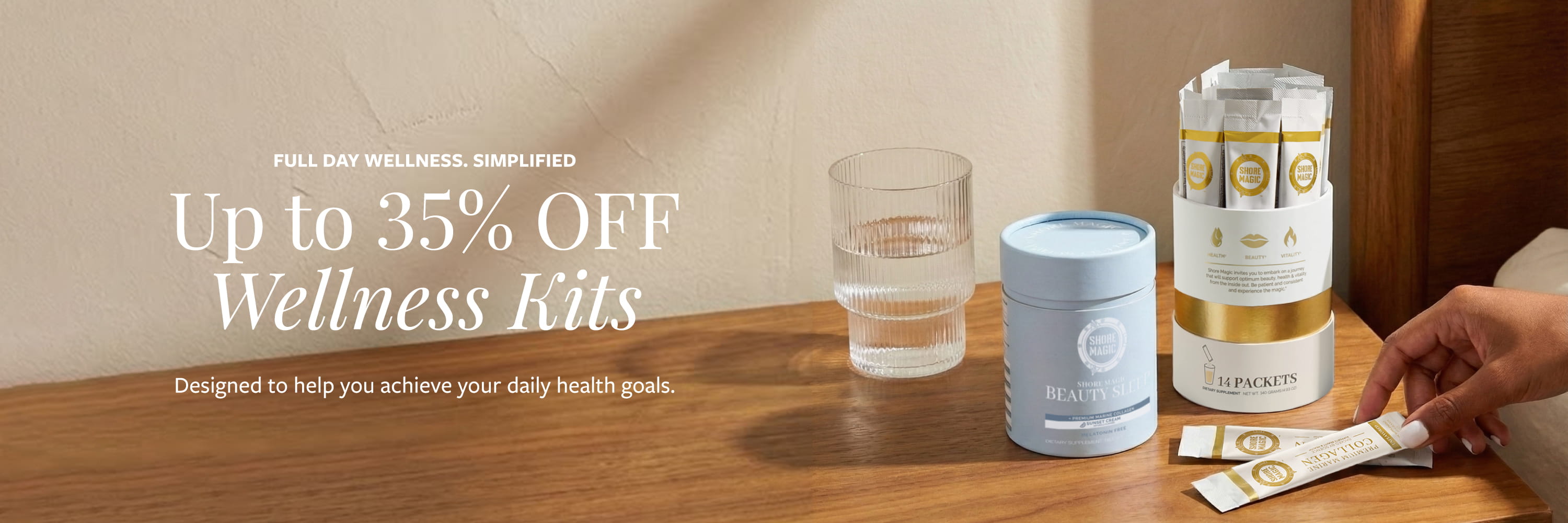 Woman reaching over Shore Magic AM and PM Ritual Kit featuring collagen stick packs and Beauty Sleep on a wooden nightstand next to a glass of water 